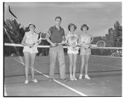 Three girls and a guy with tennis racquets